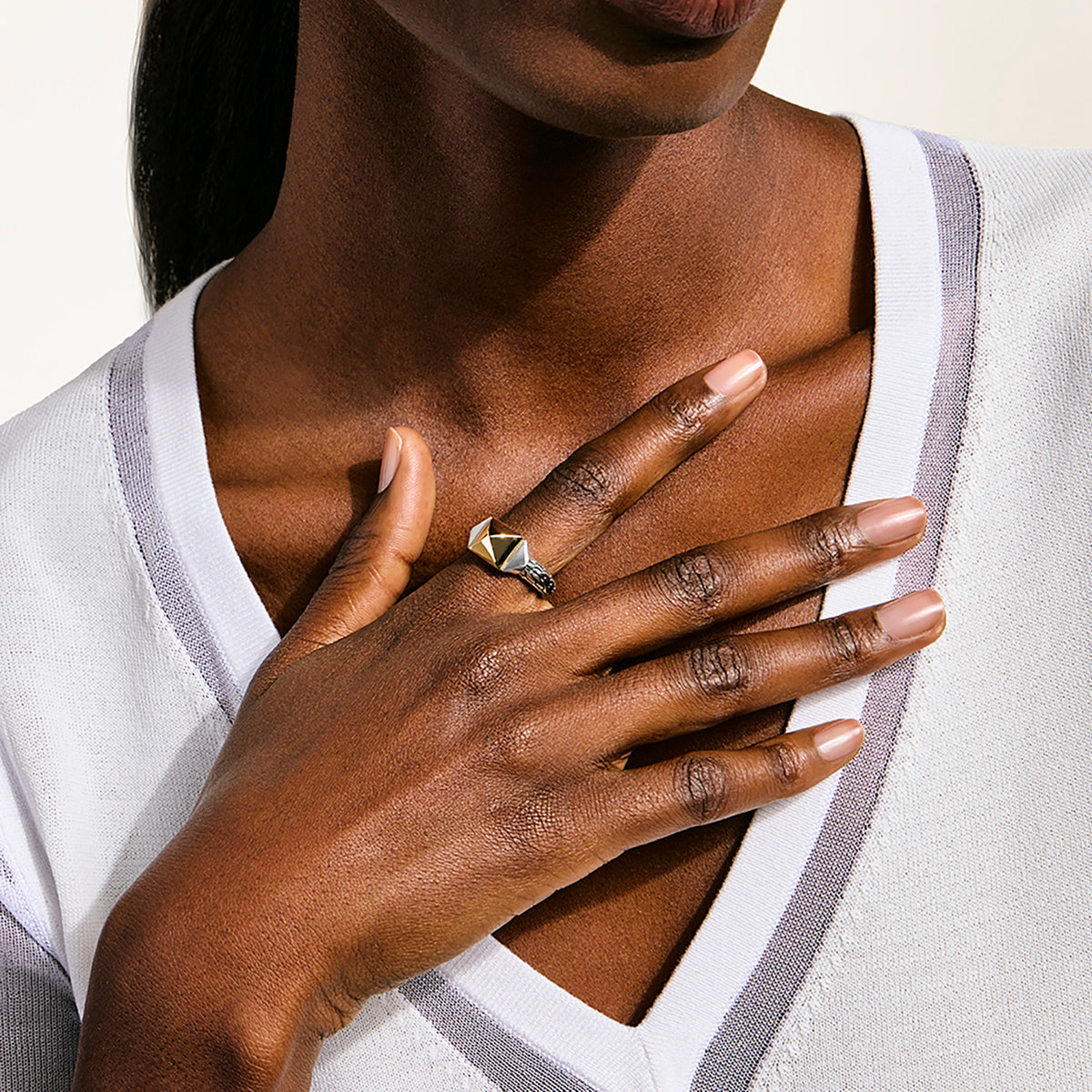 Close-up of a person wearing a gold ring on their hand